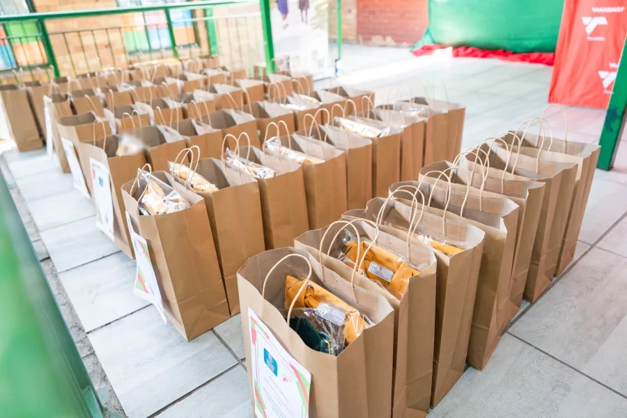 Rows of individually labelled uniform bags laid out before the handover at Inxiweni Primary School