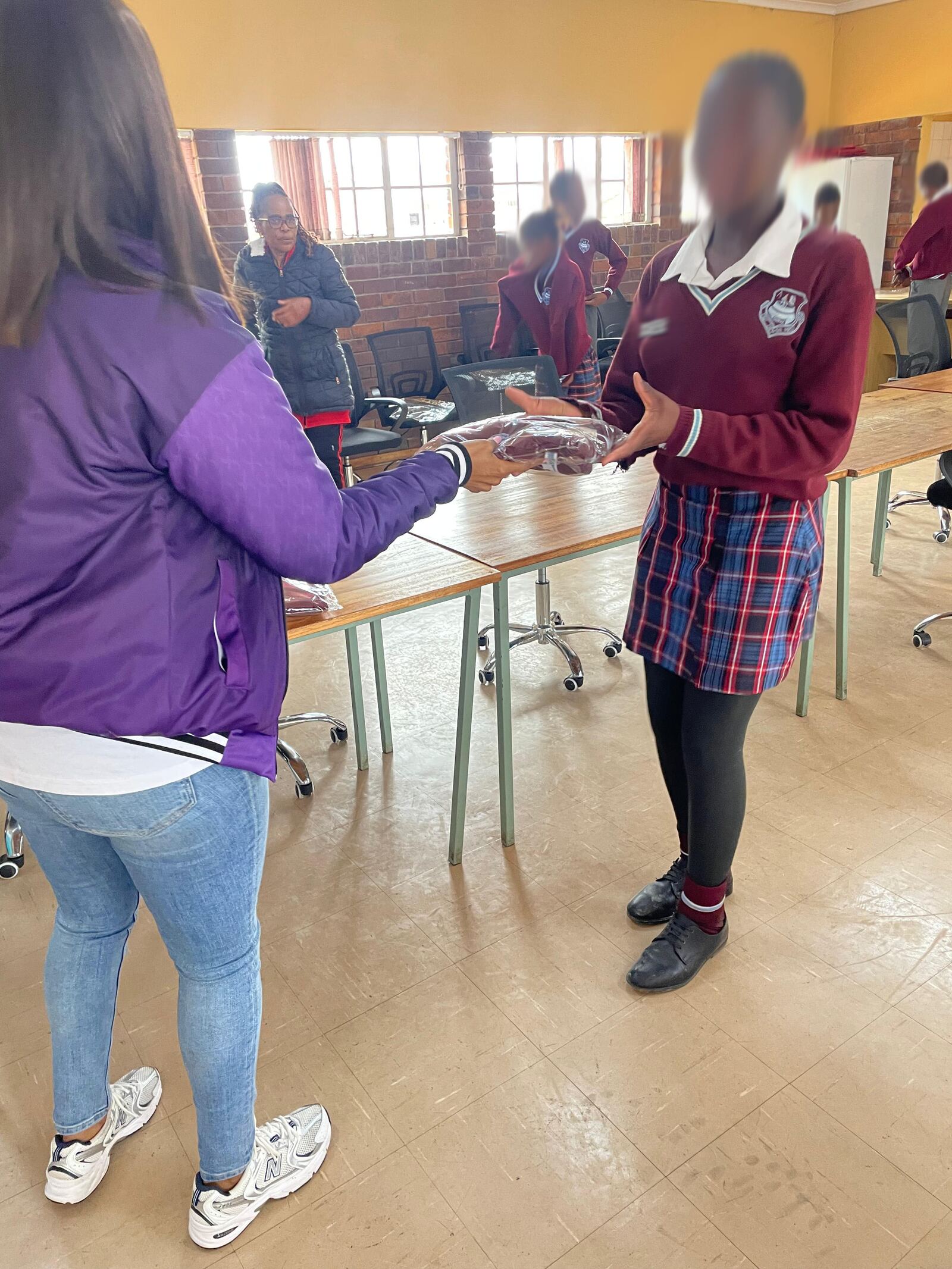 A Masisebenze Comprehensive School learner receiving her new school jersey from a Threads for iKasi Foundation representative, 27 August 2026