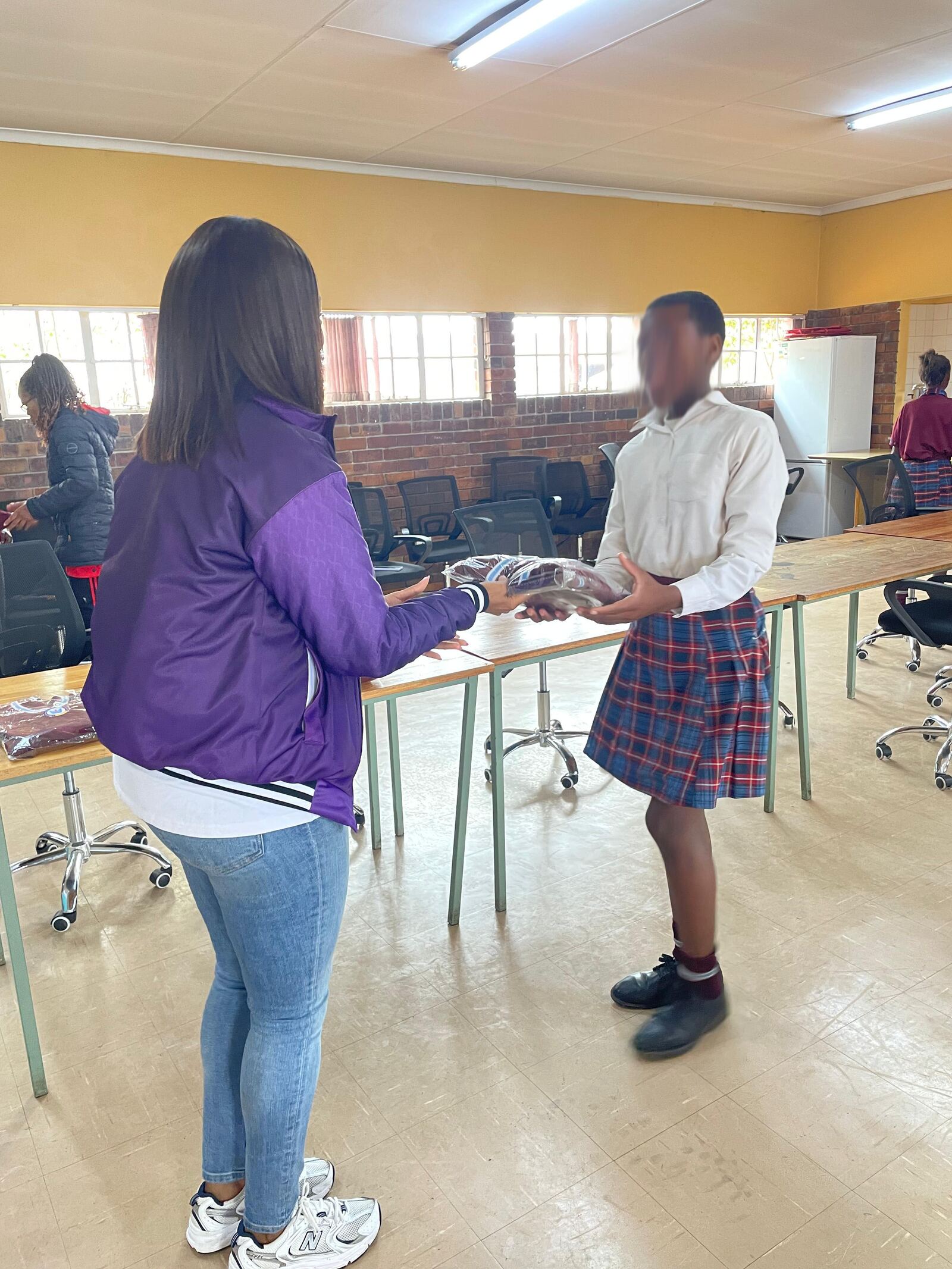 A Masisebenze Comprehensive School learner receiving his new school jersey indoors, 27 August 2026