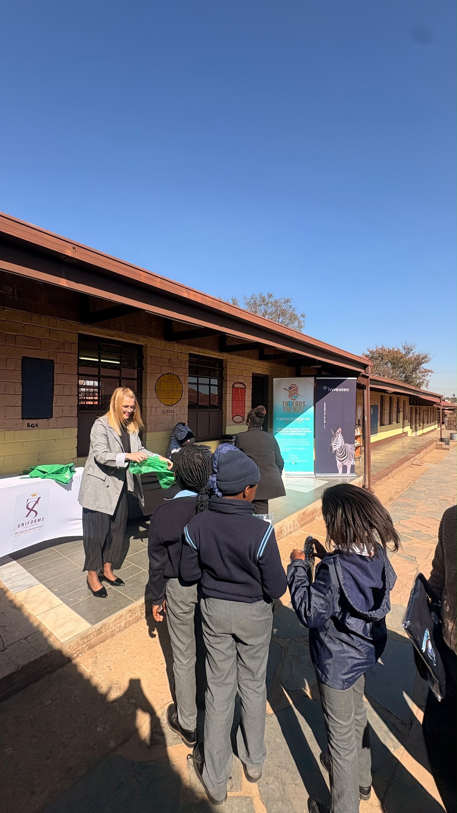 An Investec representative handing over a school jersey to a learner at Sindawonye Primary School, Mamelodi, 28 July 2026