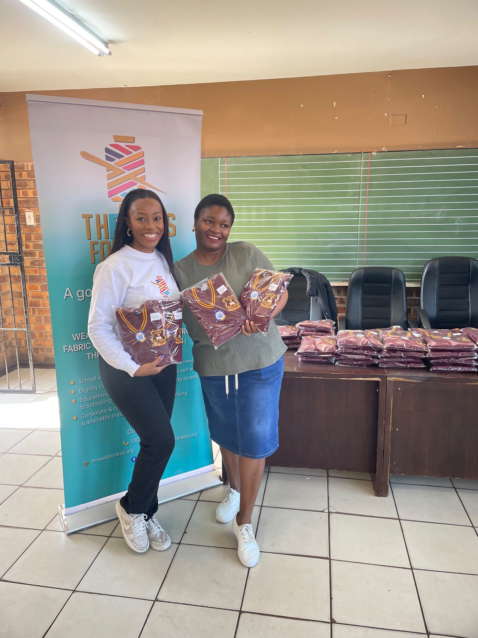 Threads for iKasi Foundation representatives holding labelled Thuthuka Primary School jerseys ready for handover