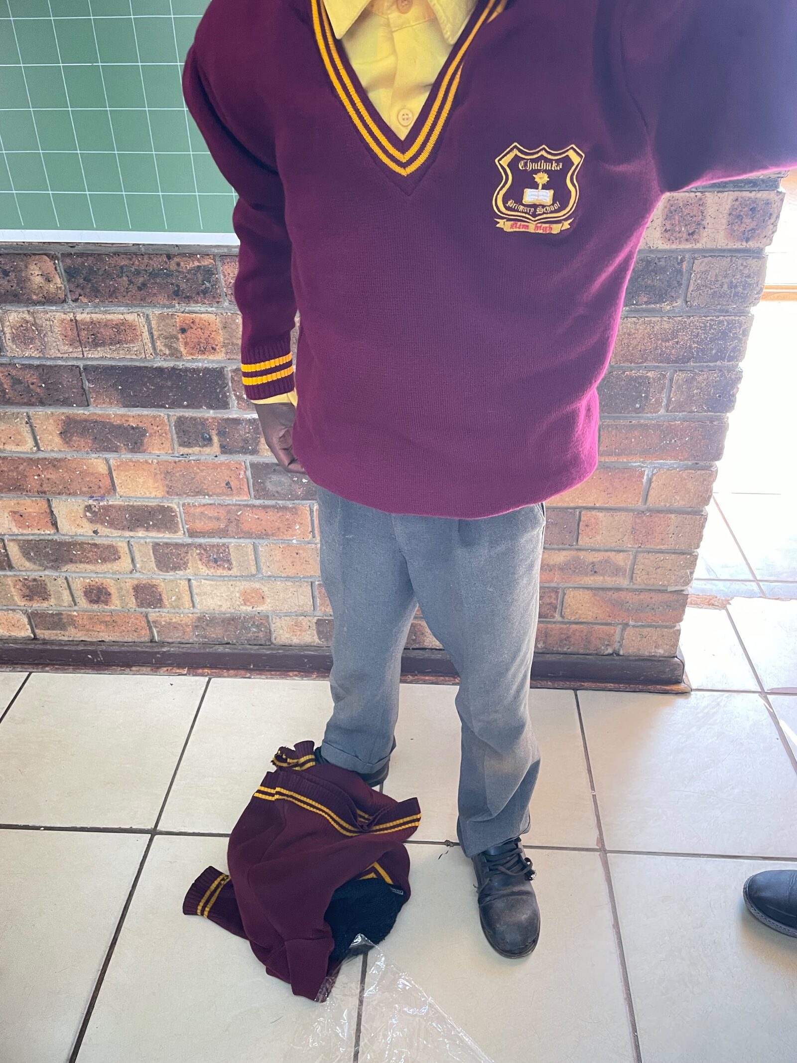 A Thuthuka Primary School learner wearing a new maroon and gold school jersey after the handover